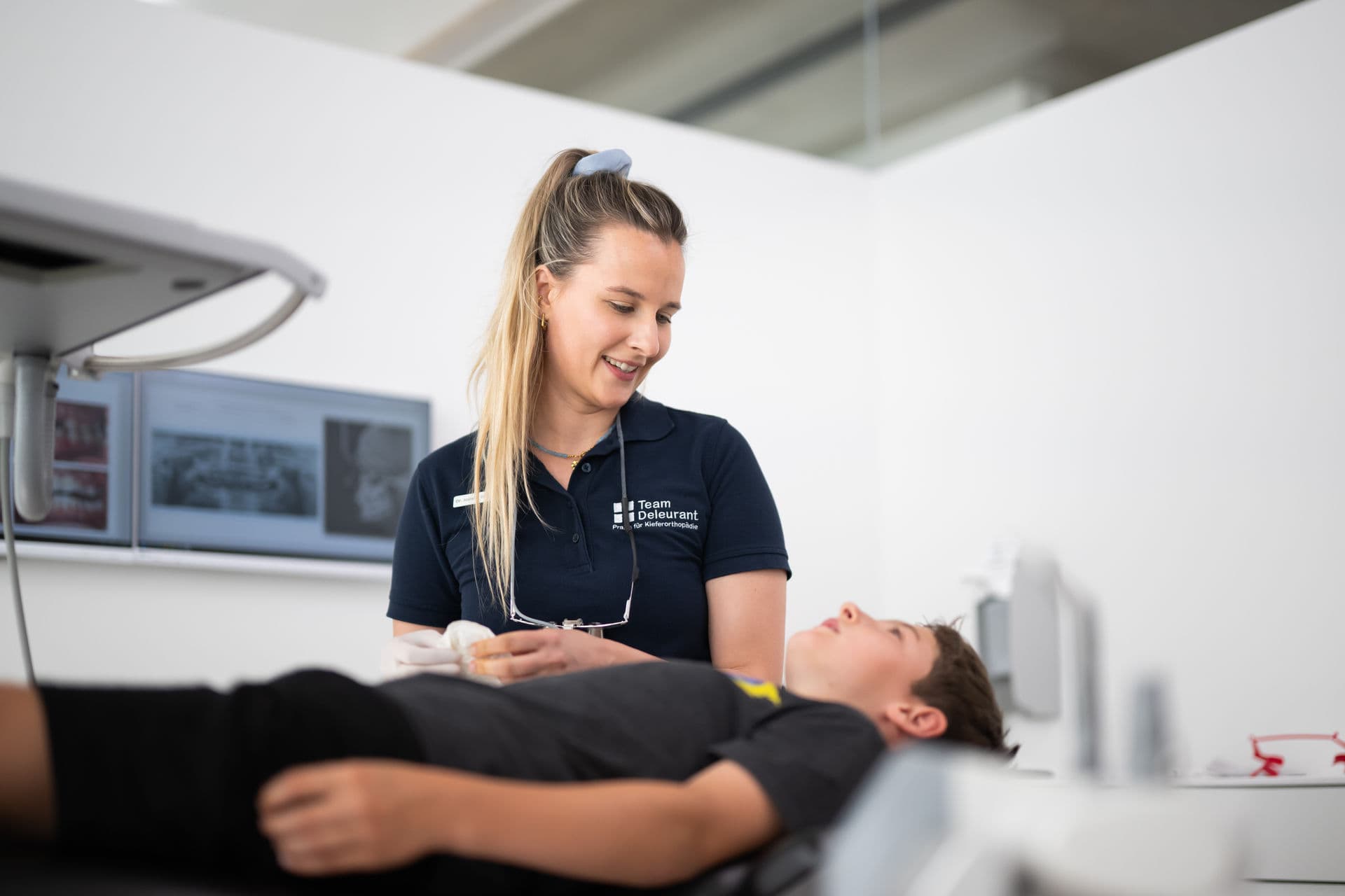 Behandlerin betreut einen jungen Patienten auf dem Behandlungsstuhl